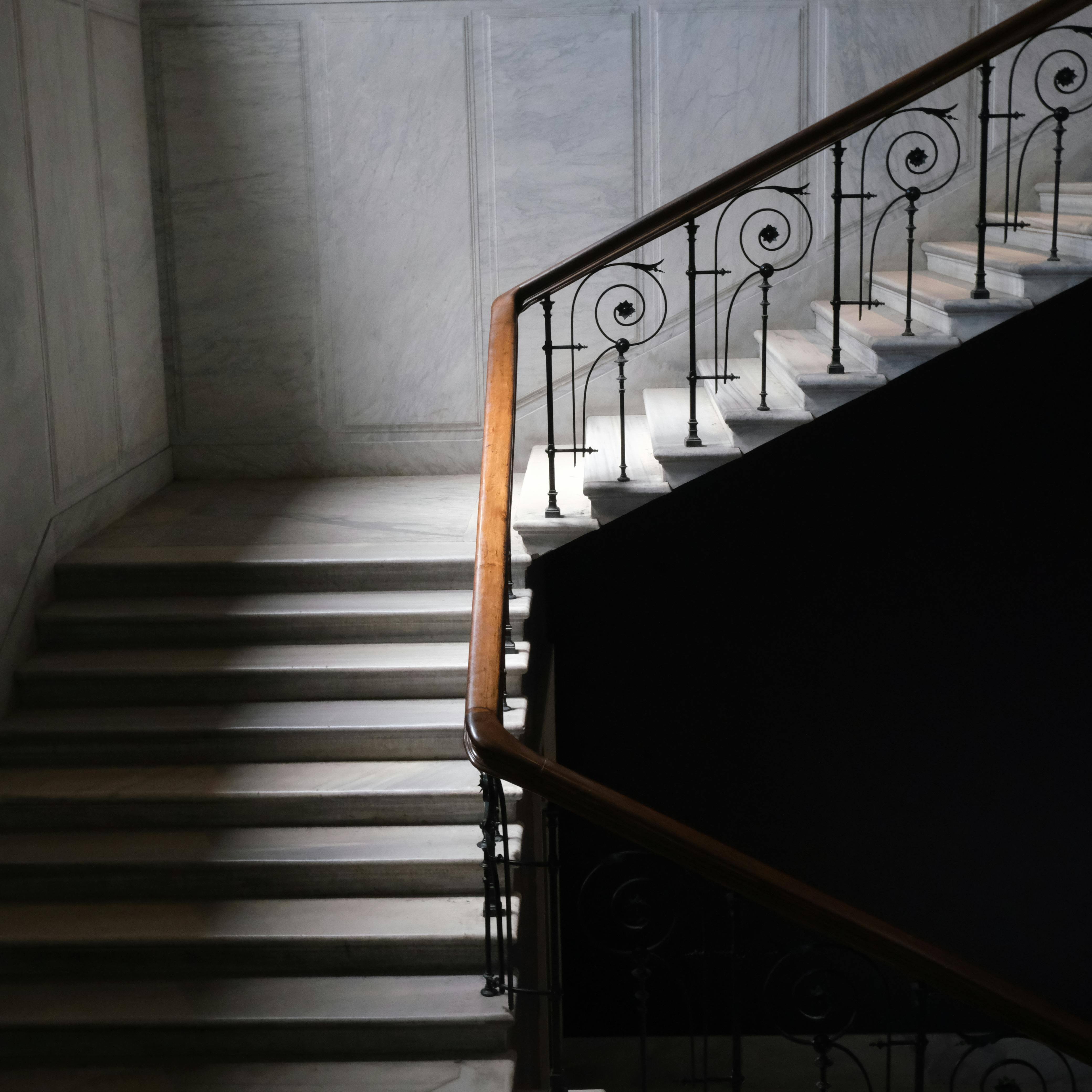 Escalera de marmol blanco con pasamanos de forma y madera