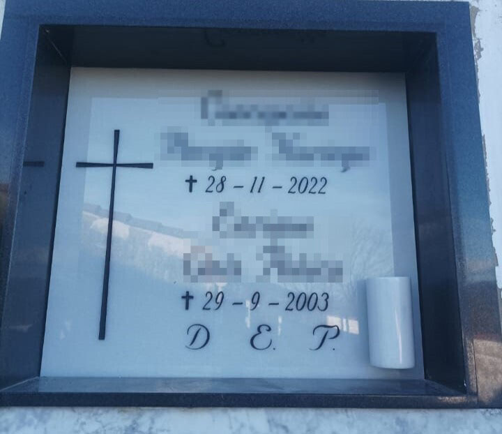 Arte funerario en blanco con cruz e inscripcion grabada en negro con búcaro