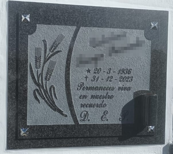 Arte funerario en negro grabada en relieve con imagen de espigas de trigo e inscripcion, y búcaro en granito
