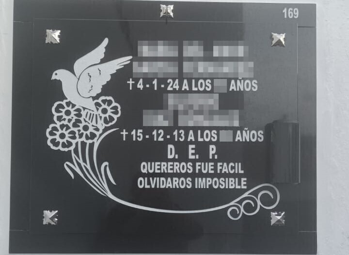 Arte funerario en negro con grabado de paloma sobre flores e inscripción pintada blanco