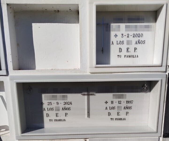 Lápidas en cajón blanco con cruz e inscripción en letras de acero inoxidable