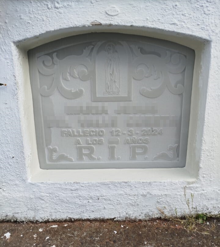 Lápida en blanco con grabado de santo e inscripcion en relieve